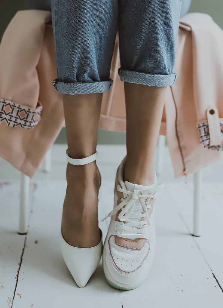 Close-up of mismatched shoes, combining elegance and casual style.