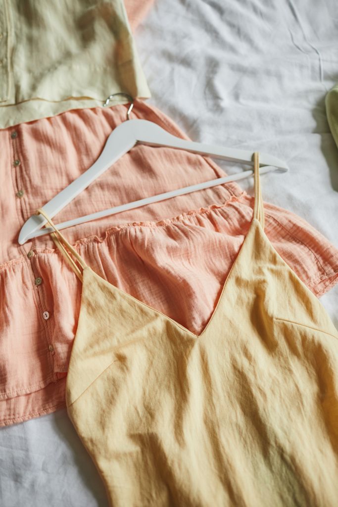 Close-up of stylish pastel dresses on hangers, ideal for summer fashion inspiration.