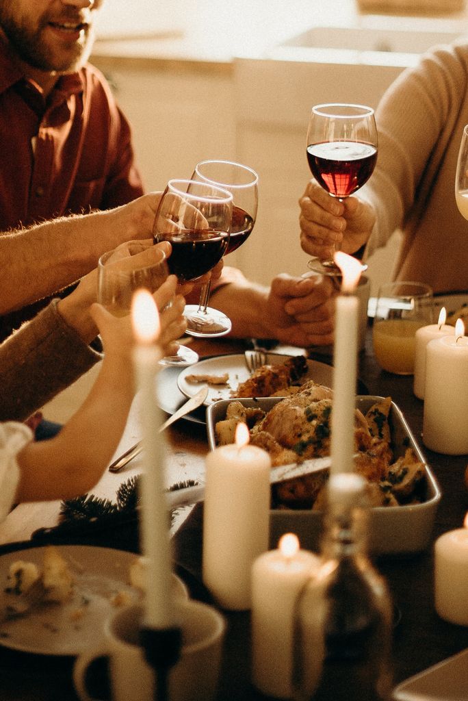 Dinner party scene with a warm atmosphere and happy people wine toasting illustrating that warmth and connection are what make a successful gathering